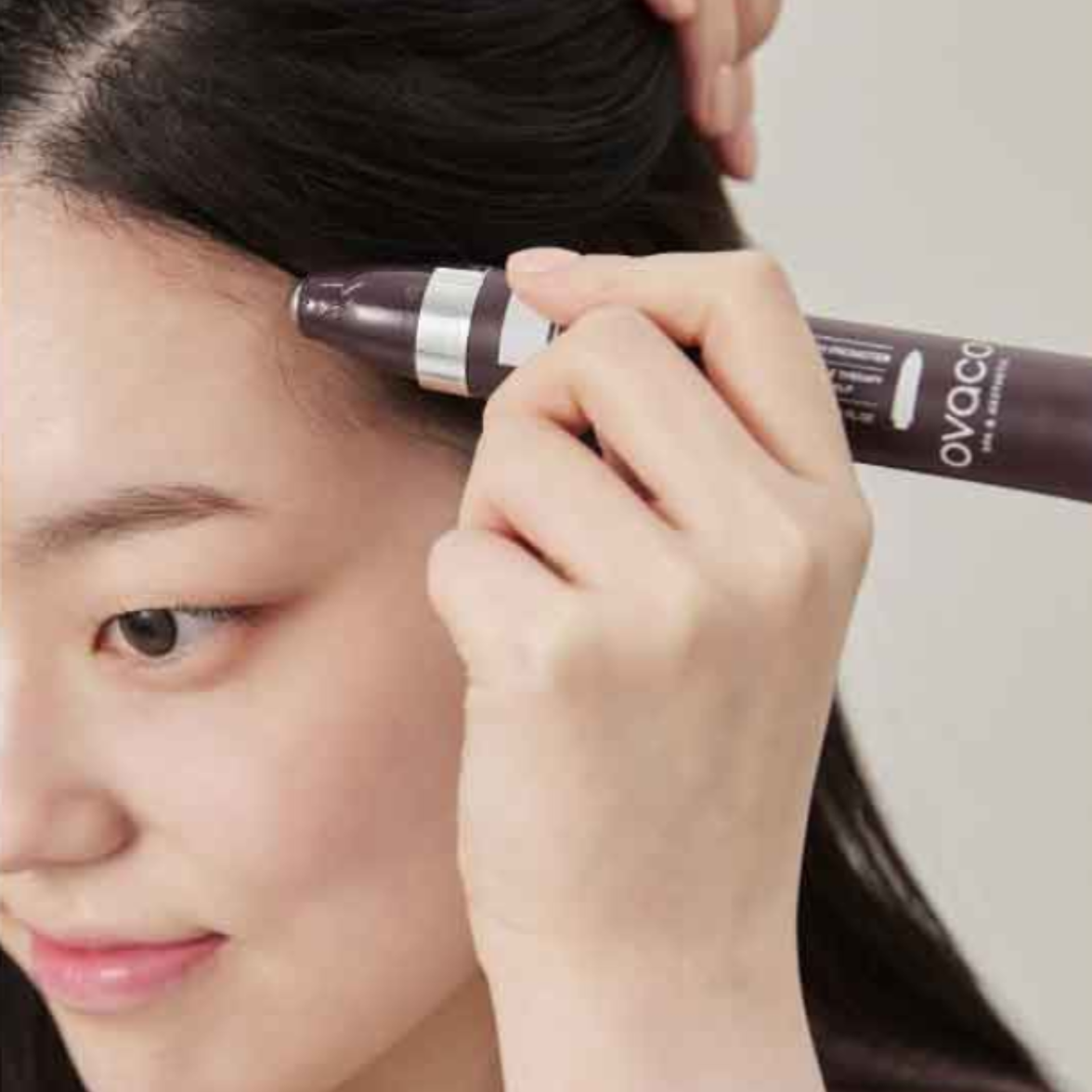 Woman using the Ovaco Biorepair Scalp Ampoule pen onto her hairline