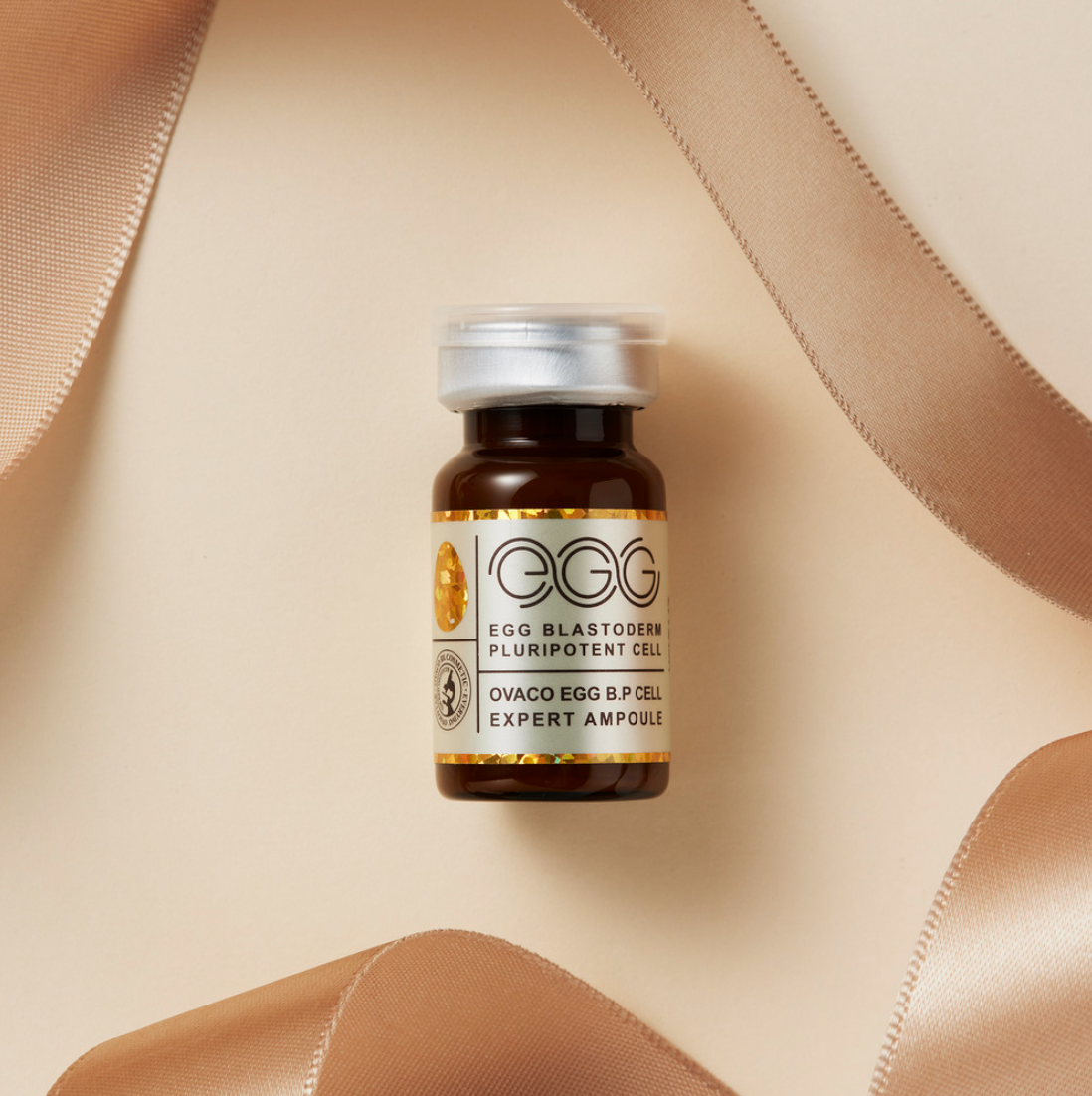 A single vial of the Ovaco Egg BP Cell Ampoule on a gold background with gold ribbon frame